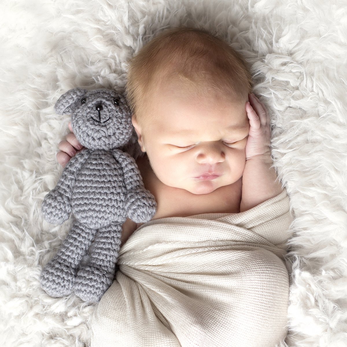 Newborn baby in wrap and mini teddy bear. Photo by Natural Impressions Photography by Justine photographer in Bismarck ND